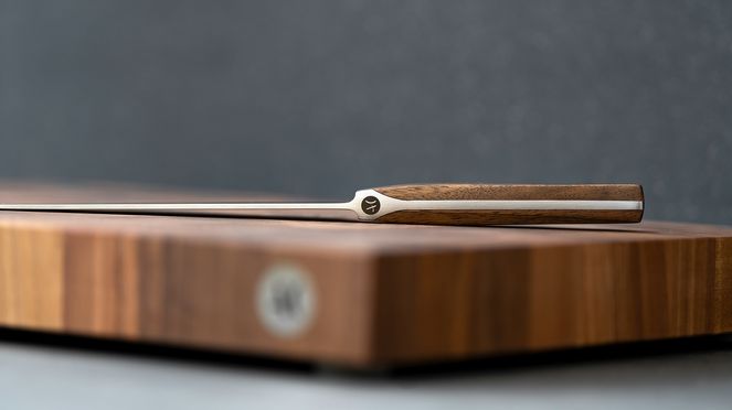 
                    Coltello per prosciutto Caminada con fodera di legno sul blocco di taglio Caminada